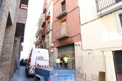 Operarios volviendo a tapiar la entrada al edificio calcinado. 