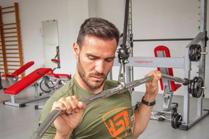 Saul Craviotto trabajando en el gimnasio con máquinas de musculación y pesas.