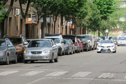 Un coche en doble fila con el vehículo de la Guardia Urbana equipado con el CiviCar justo detrás