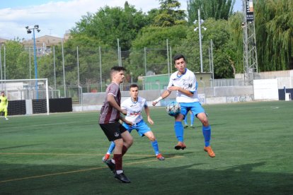 Un jugador del Mollerussa intenta controlar una pilota alta davant d’un rival del Júpiter.