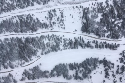 Vista aérea de las curvas del puerto de la Bonaigua cubiertas de nieve (izquierda). En la imagen derecha, esquiadores en las pistas de Port Ainé. 