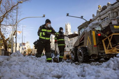 Efectivos de la UNE efectuaron ayer labores de limpieza de las calles de Madrid llenas de nieve.