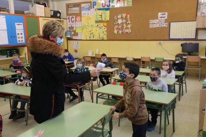 Una maestra del Frederic Godàs tomando ayer la temperatura a sus alumnos justo después de entrar en clase.