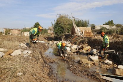 Imagen de los operarios de la CHE trabajando ayer para reparar las obstrucciones en el caudal del río en L’Albi tras las inundaciones. 