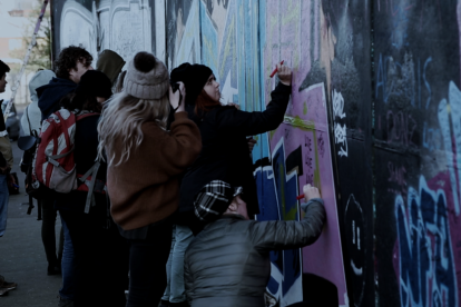 Un grup de joves pinta un mural en un carrer de Belfast.