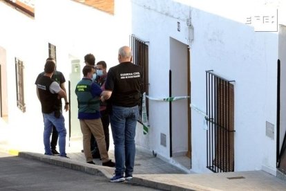 Varios agentes frente a la vivienda donde hallaron los cuerpos.