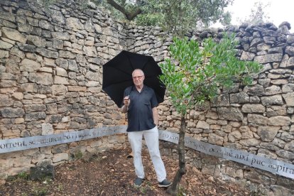 El artista Antoni Llena junto a su obra ‘Món’ en la Vinya dels Artistes, en el Celler Mas Blanch i Jové.