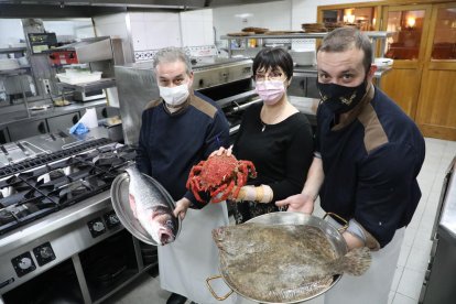 A la derecha, Héctor, el ganador, con sus padres, Ángel y María Teresa, en la cocina del restaurante.