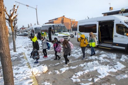 Alumnos bajando ayer del autocar del transporte escolar en Guissona. 