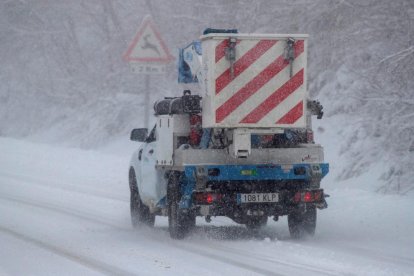 Un vehículo de trabajo para el mantenimiento de la red eléctrica circula en la carretera en plena helada.