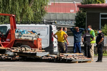 Agentes policiales junto a asistentes de servicios de emergencia en el lugar del accidente.