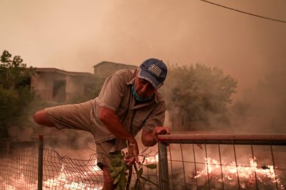 Un hombre huye de las llamas de un incendio en la localidad griega de Pefki, ayer.