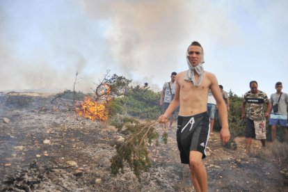 Veïns de la ciutat tunisiana de Bizerta intenten sufocar les flames que han arrasat la Muntanya Nadhour.