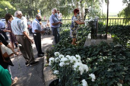 Veïns dipositant clavells blancs al monument de Butsènit que recorda la tragèdia.