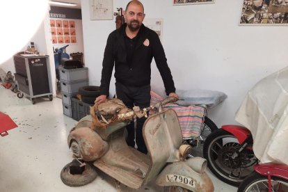 Rafael Roig, propietari del taller, amb una Vespa a restaurar.