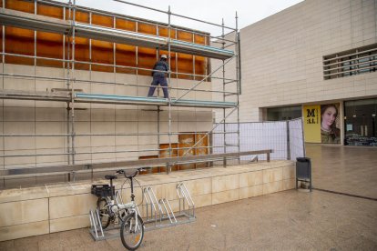 Un operario trabajando ayer en una de las fachadas afectadas, en la que ya se han retirado las placas de piedra de las filas superiores.