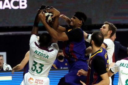 El blaugrana Brandon Davies lluita amb Yannick Nzosa.