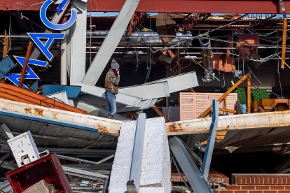 Una dona observa els danys ocasionats pel tornado en un comerç a Kentucky.