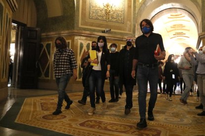 Plano general de los negociadores de ERC, Juntos y la CUP caminando por los pasillos del Parlamento