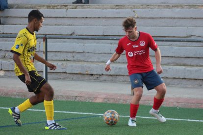 Llusà controla el esférico ante la presión de un jugador rival.