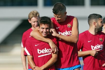 Gerard Piqué fa broma amb Riqui Puig durant l’entrenament blaugrana de divendres.