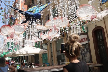 Una visitant fotografia la decoració del carrer Verdi de Gràcia.