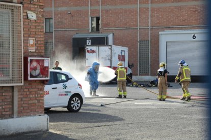 Bombers netejant l’equip de protecció d’un company.