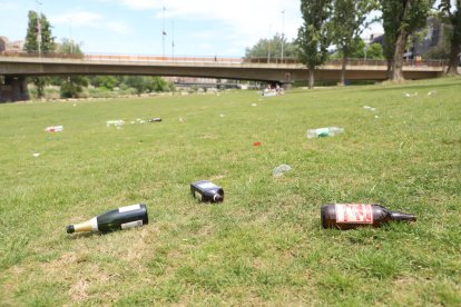 Diverses botelles d’alcohol buides i bosses de plàstic escampades ahir al migdia a la canalització.