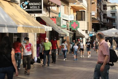 Varias personas paseando ayer por el Eix Comercial con mascarilla.