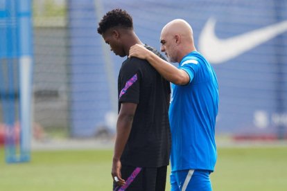 Ansu Fati ayer durante una pausa del entrenamiento junto al recuperador físico Juanjo Brau.