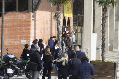 Varias personas de colectivos esenciales hacen cola para vacunarse.