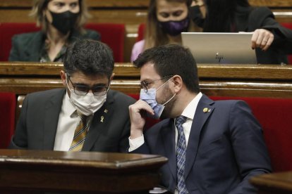 El presidente de la Generalitat, Pere Aragonès, habla con el vicepresidente del Govern y conseller de Políticas Digitales, Jordi Puigneró, al inicio de la sesión de control en el pleno del Parlament.