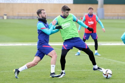 Pjanic y Piqué, en una acción de la sesión de entrenamiento de ayer.