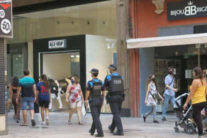 Agents de la Guàrdia Urbana patrullant per l’Eix Comercial.