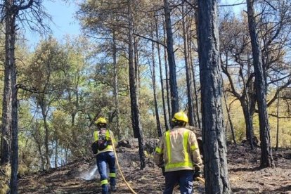 Bomberos ayer remojando la zona. 