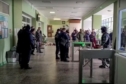 Policías y algunos alumnos en el edificio del tiroteo tras el suceso.