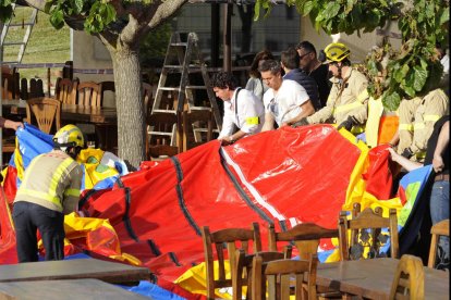 Operarios y bomberos retiran el hinchable del restaurante.