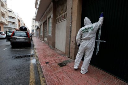 La policía precinta la puerta de la vivienda donde sucedió el crimen.