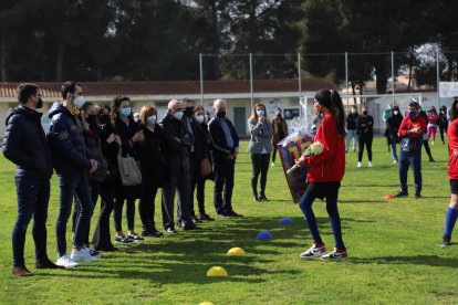 Una jugadora del Soses Femení entrega a la familia una camiseta firmada por toda la plantilla y un ramo de flores.