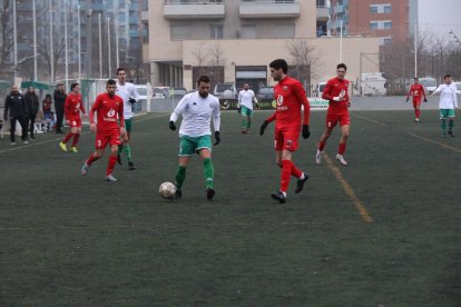 Un defensa del Alpicat presiona a un jugador del Balàfia, que trata de superarle.