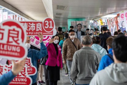 Varios voluntarios animaron ayer a los hongkoneses a votar.