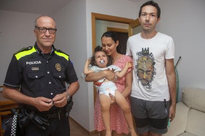 El caporal de la Policia Local de Tàrrega Antoni Gutiérrez al costat de la família i el petit que va salvar ahir al seu habitatge a Tàrrega.