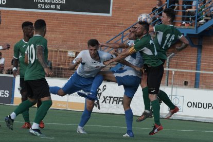 Un jugador del Mollerussa es agarrado por la camiseta por un rival ayer durante el partido de ida de ascenso a Tercera RFEF.