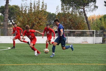 Un jugador de l’Albi controla la pilota davant de la pressió d’alguns dels jugadors de l’Alpicat.