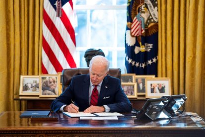 El presidente de los Estados Unidos, Joe Biden, firmando una orden legislativa en el despacho oval.