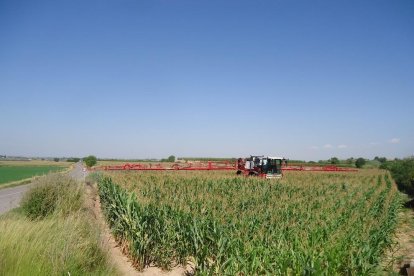 Una màquina aplicant tractaments fitosanitaris sobre un camp.