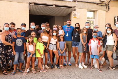 Saúl posa ante la puerta de su casa junto a su familiares, amigos y vecinos que se reunieron para darle la bienvenida.