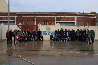 Alumnes i professors de l’institut, al costat del mural col·lectiu a favor de la sostenibilitat.