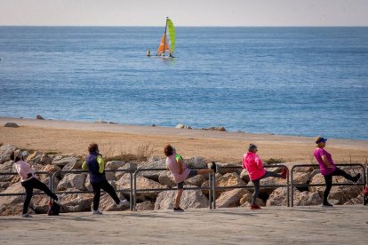 Diverses persones fan exercici a la platja barcelonina de Nova Icària.