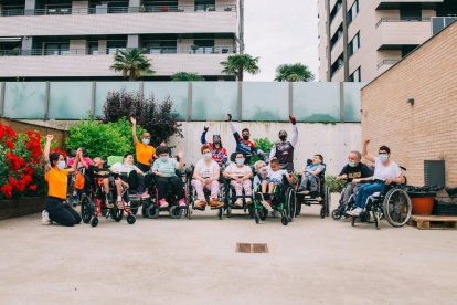 Miembros de la asociación Aremi posan con los tres pilotos del equipo Lleides tras la exhibición en las instalaciones de la residencia.